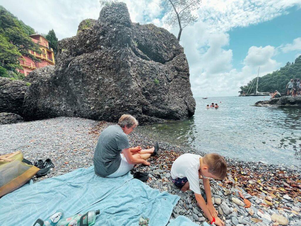 Beach in Portofino, Italy with child playing with rocks