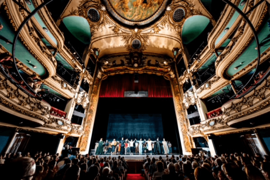 French opera house.  people on stage with surrounding crowd