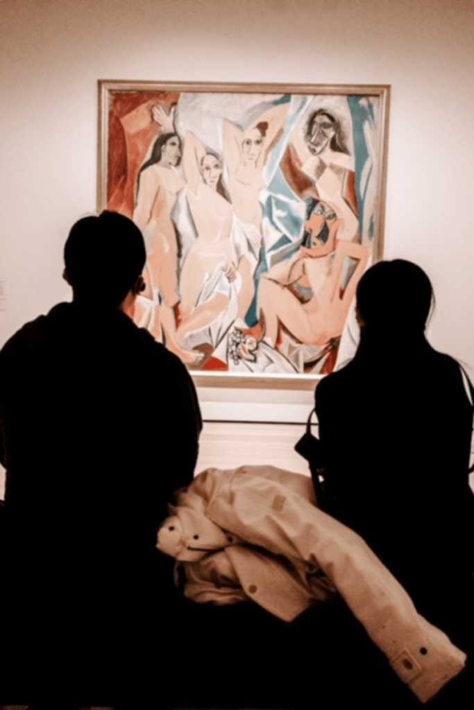 Two people in a museum looking at a Picasso painting