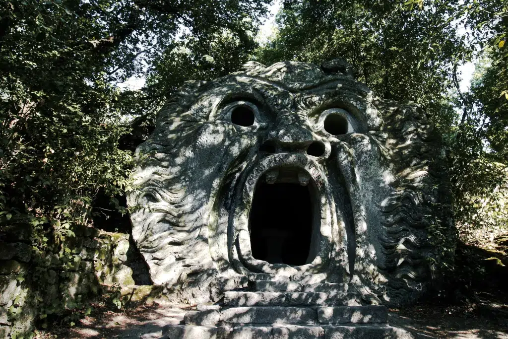 Stone statue of a face.  The statues mouth is open. Day trips from Rome in Winter