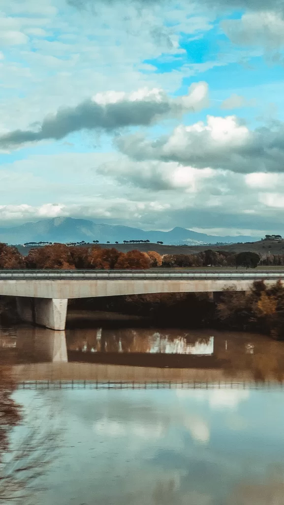 Bridge over Arno river in italy with mountains in the background