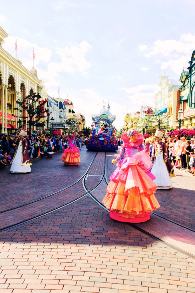 Women in colorful costume going down main street at Disney World