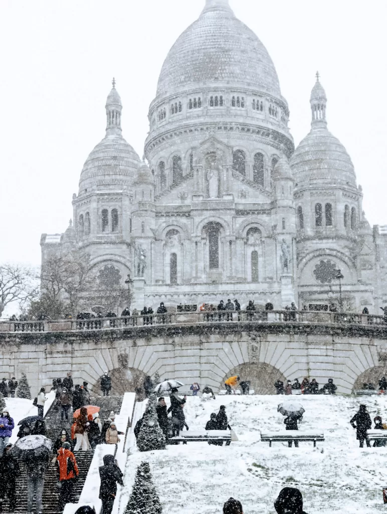 Large white church in paris with Dome.  Sacre Coeur.  Snow is surrounding the building