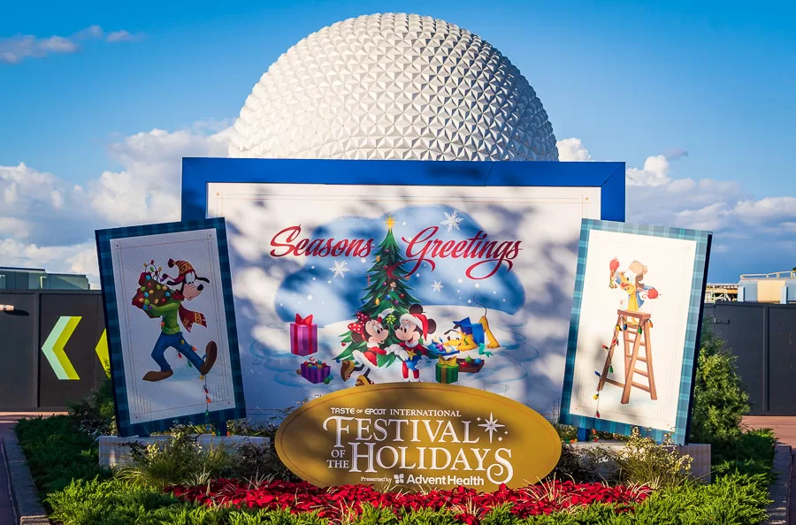Epcot spaceship rearth with sign for international festival of the holidays promo sign in front