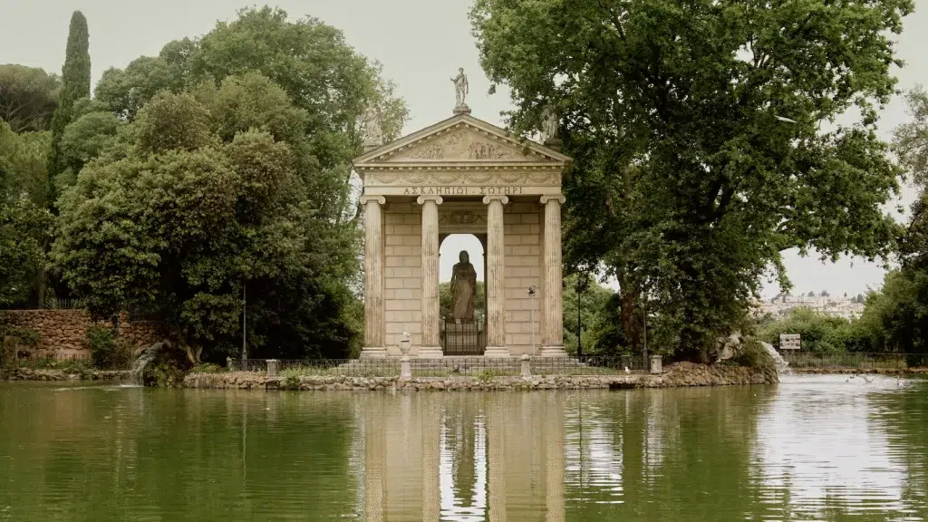 a gazebo in the middle of a lake surrounded by trees