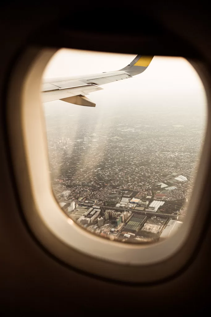 Airplane wing from the view of a passenger inside the plane through the window. 