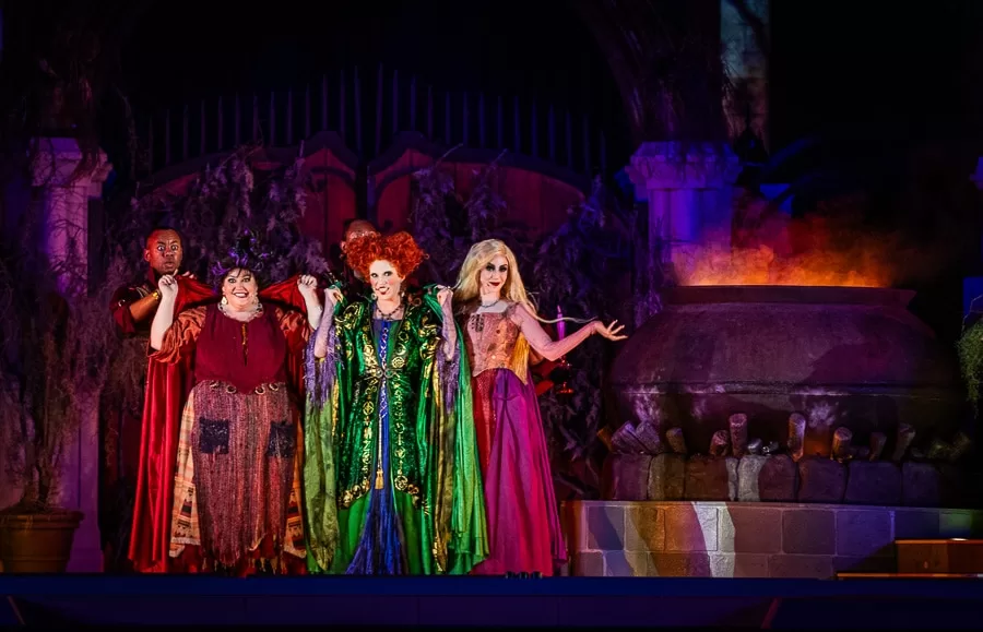 Sanderson sisters from hocus pocus.  They are wearing red, green and purple dresses