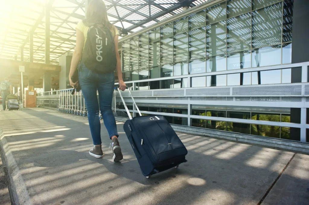 Woman Walking on Pathway While Strolling Luggage.  Best luggage for cruise