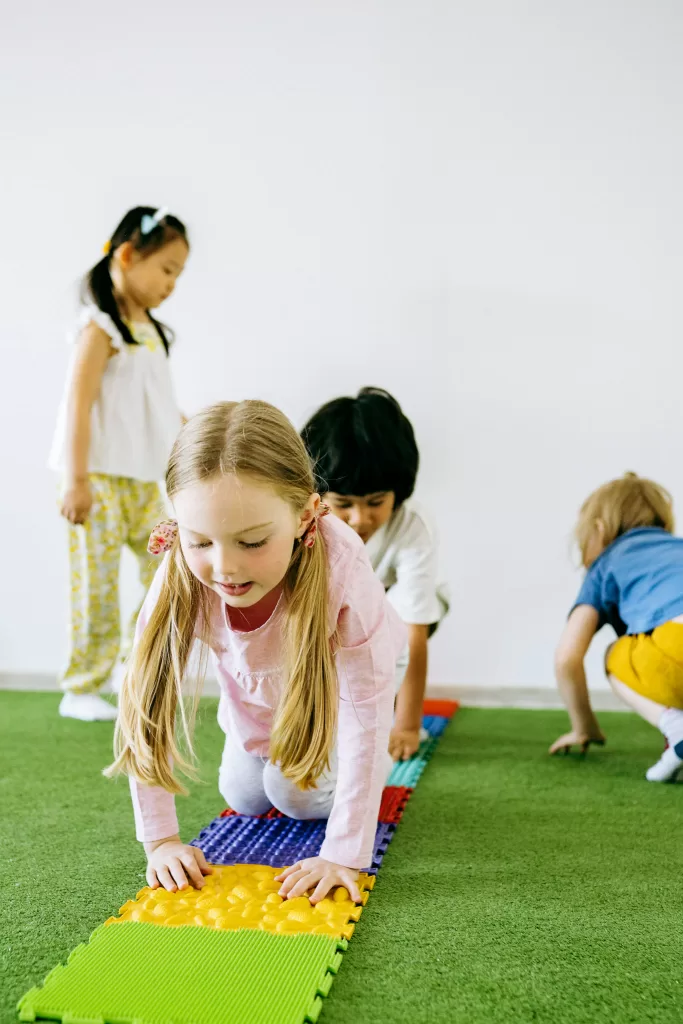 Small blonde child crawling on a padded surface at an indoor playground