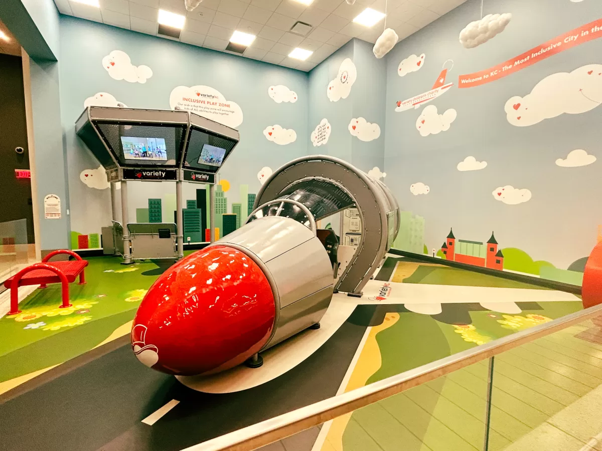 red rocket shaped play ground on a green carpet with blue walls at an airport playground