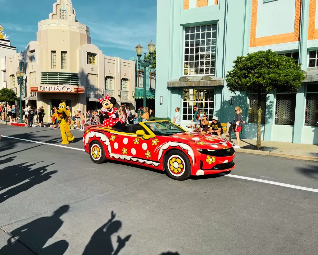 Minnie Mouse riding in a red and white polka dot car at Disney World.  What to wear to disney world in March