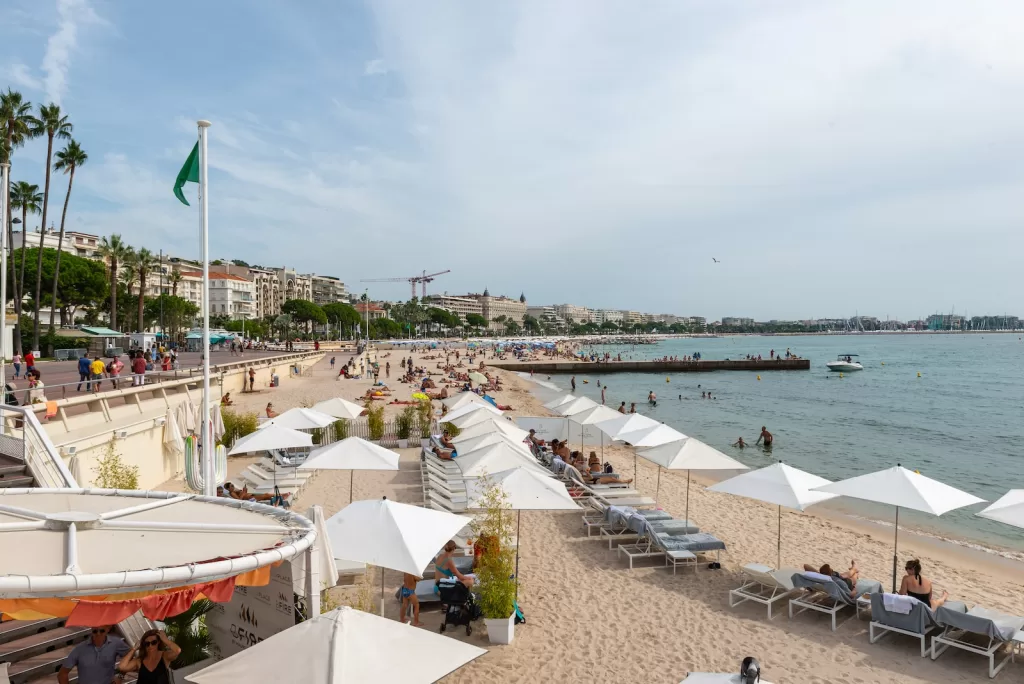 a sandy beach with lots of white umbrellas