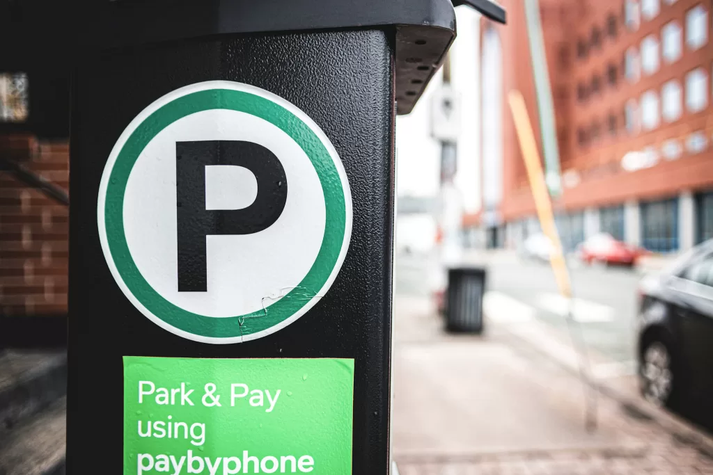 Green parking sign on a black Pole.  