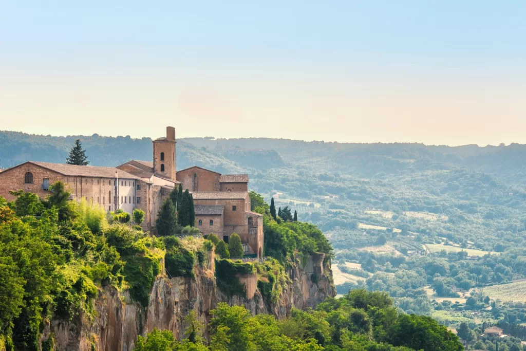 a small village on a cliff surrounded by trees