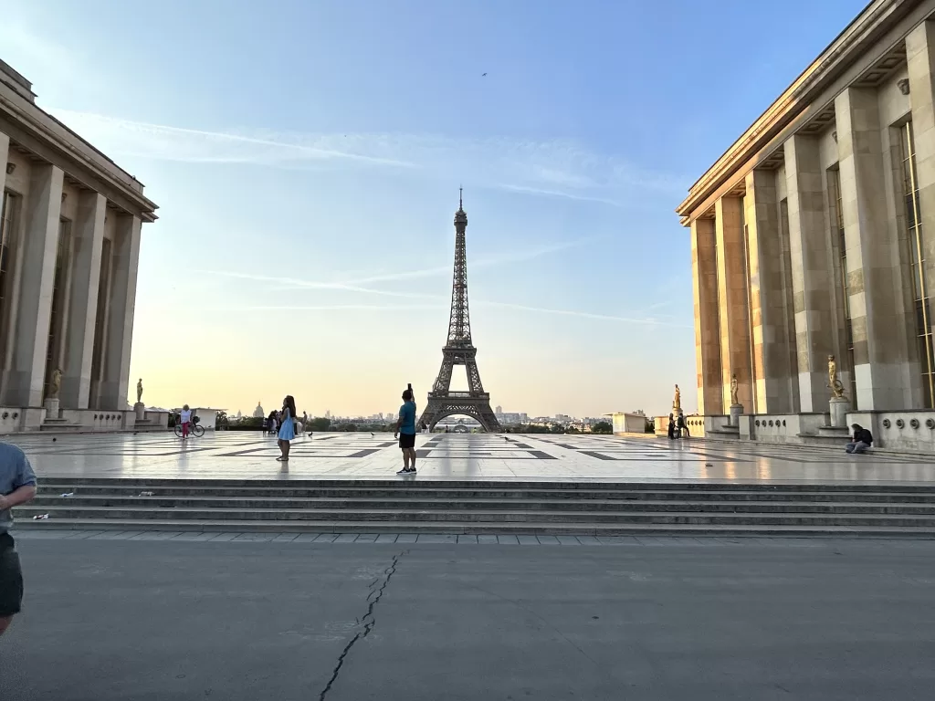 Eiffel tower at dawn with sunrising behind it.