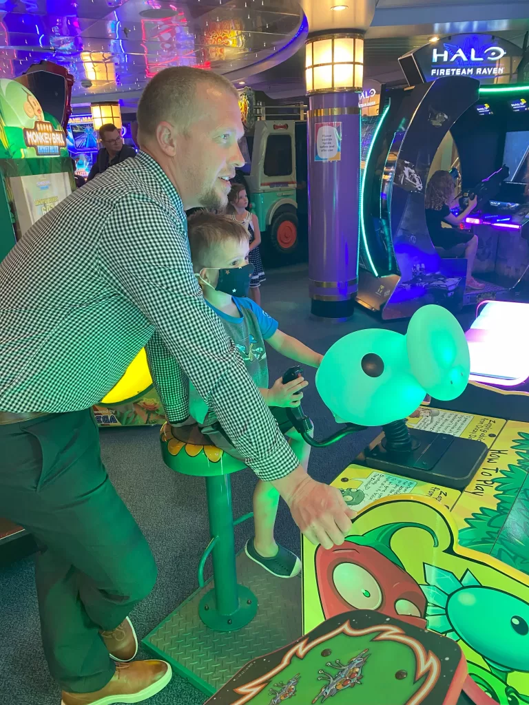 dad and son at an arcadde playing arcade game