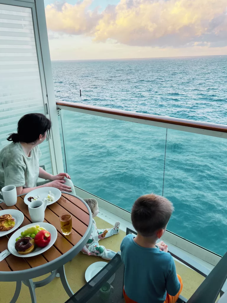 mom and toddler son sitting on a balcony overlooking the ocean