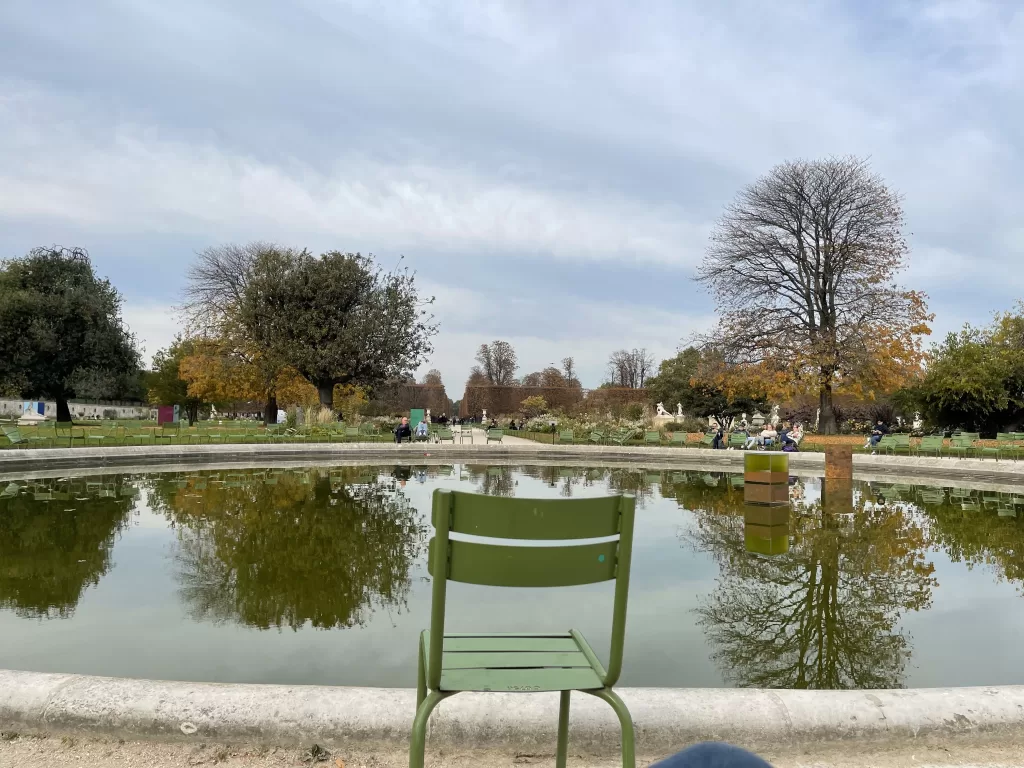 foutain in the tuillerie garden in Paris with autumn trees in the background. 