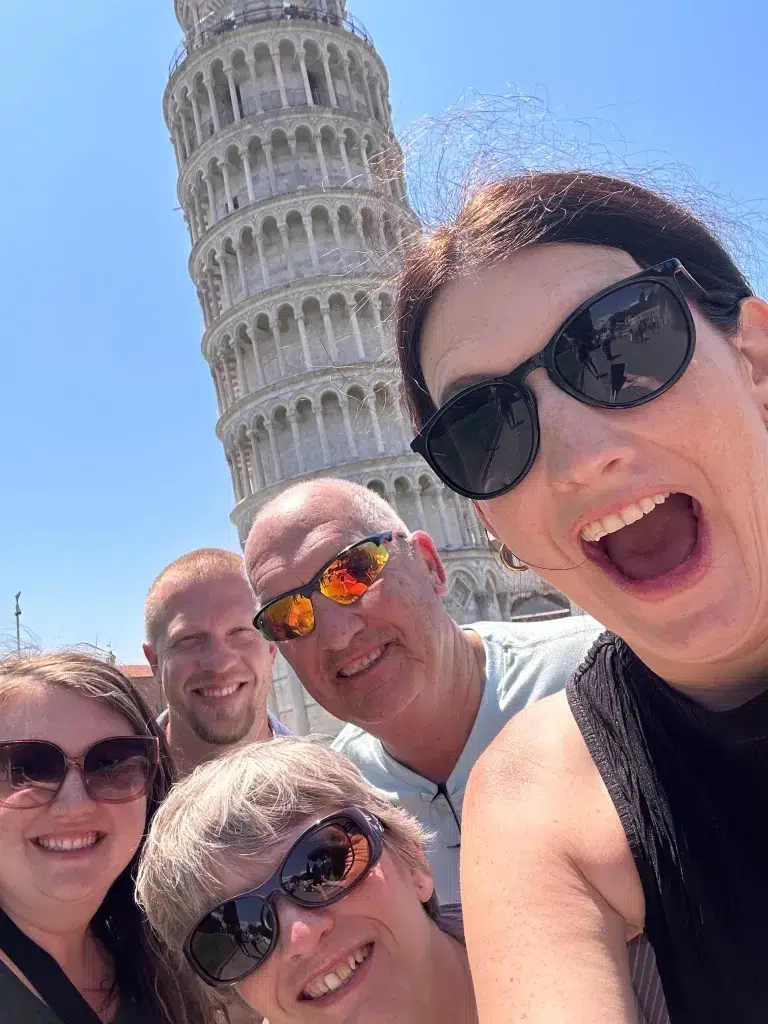 Group of family members with leaning tower of pisa in background. Livorno cruise port with kids