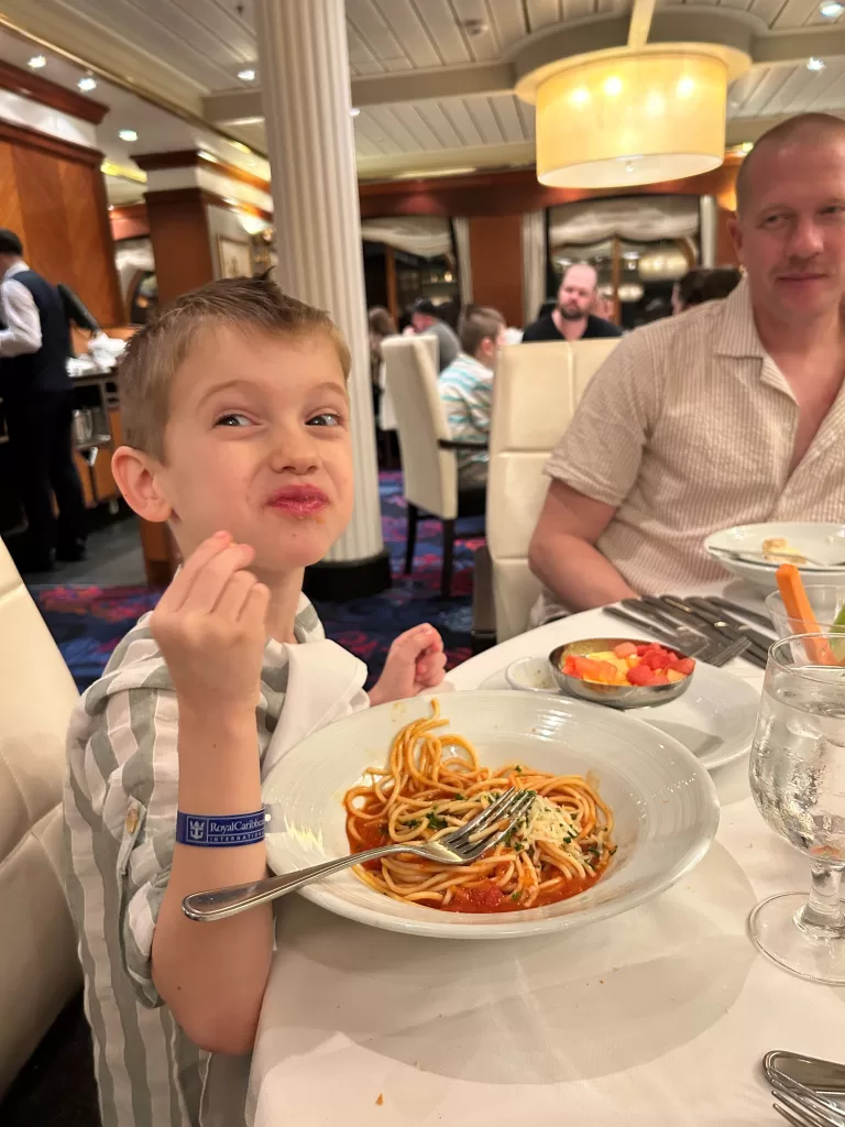 Child eating spaghetti in the main dining room on cruise ship, navigator of the seas