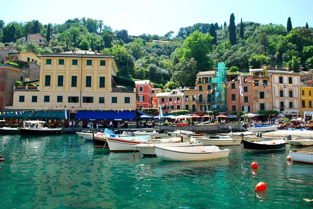 marina with boats on green blue water with colorful italian architecture in the background
