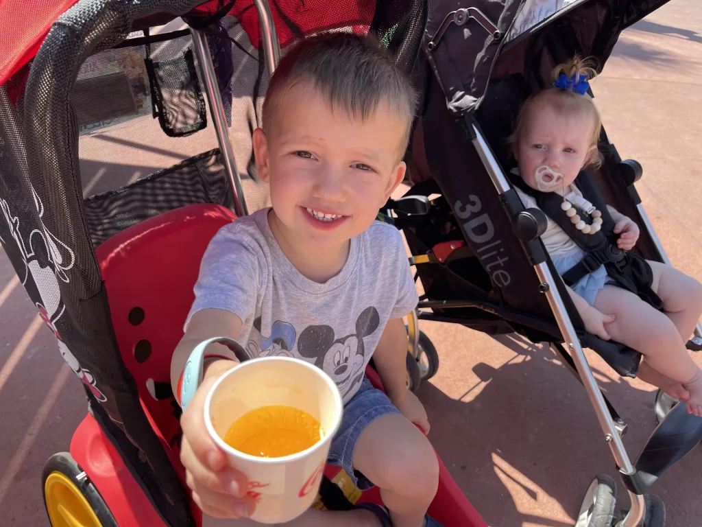 Child with glass of orange juice at Disney world epcot