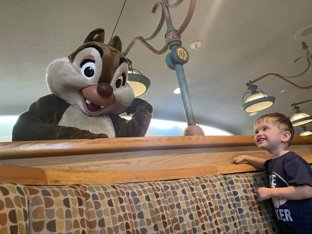 Chip from Chip and Dale with young child at Garden Grill restaurant at Disney world Epcot.