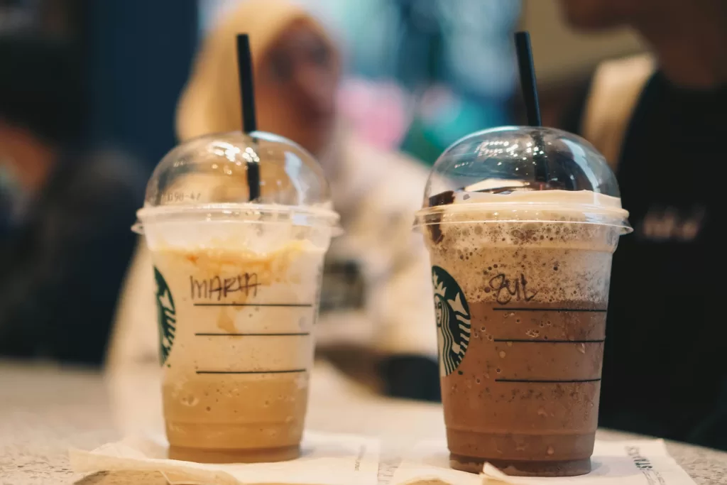 Two starbucks frappachinos sitting at a table in epcot.