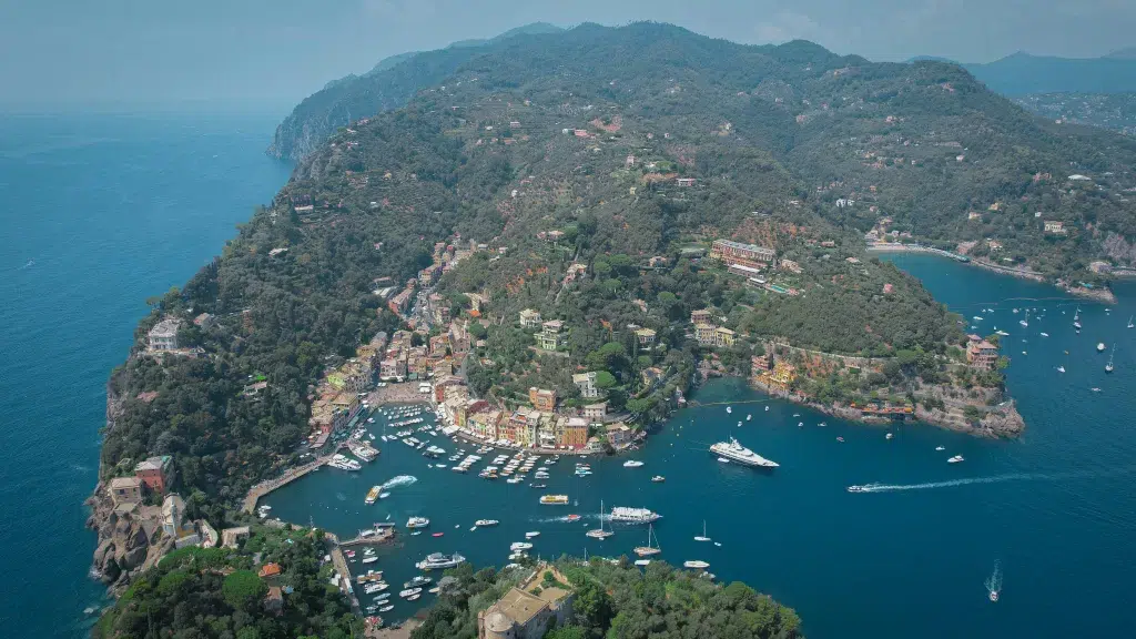 Coast of italy from an arial view. Below is blue waters and small white boats linking the coastline