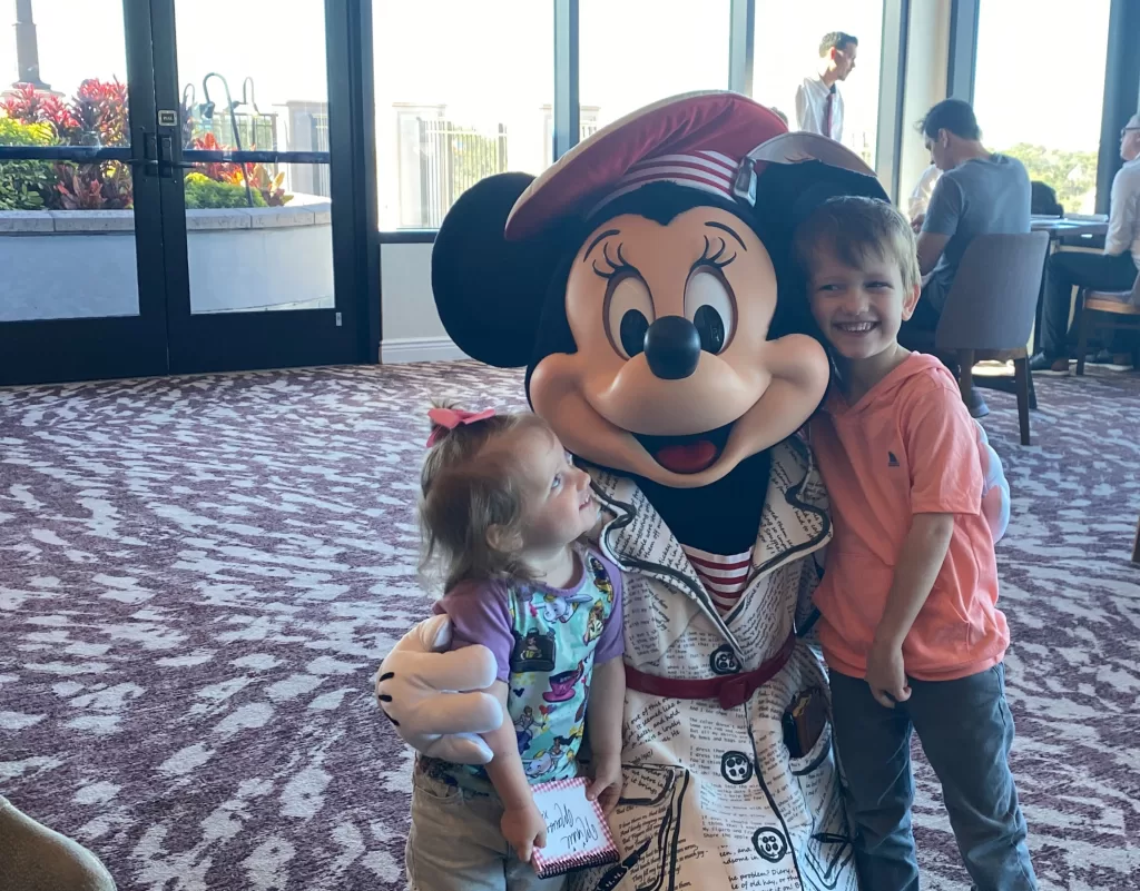Two young kids meeting minnie mouse character at Disney