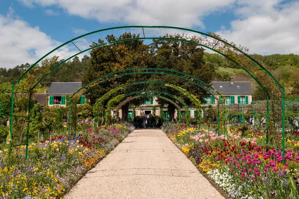 beautiful green and lush gardens with red and yellow flowers at giverny france. 