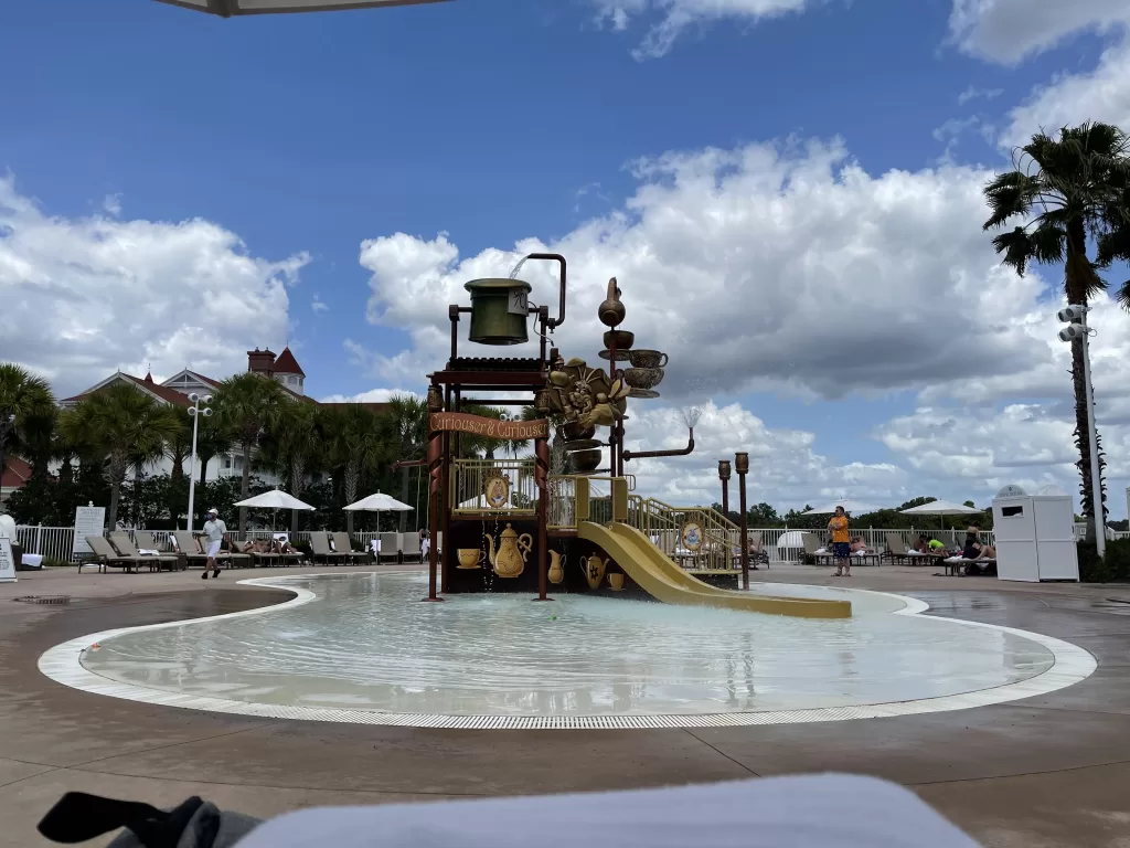 Splash pad with yellow slide and pool area at the grand floridian.  Grand floridian with kids